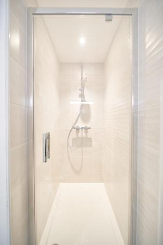 une salle de bain blanche avec une douche et un lavabo dans l'établissement Studio - L'ännexe, à Lyon