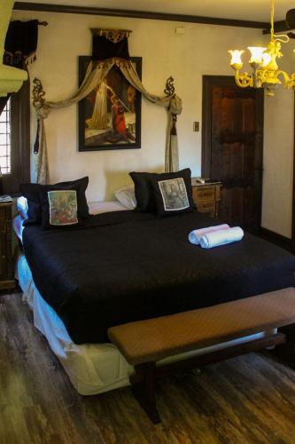 a bedroom with a large bed with a black comforter at Castillo Medieval in Viña del Mar