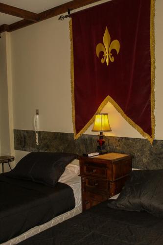 a bedroom with two beds and a table with a lamp at Castillo Medieval in Viña del Mar