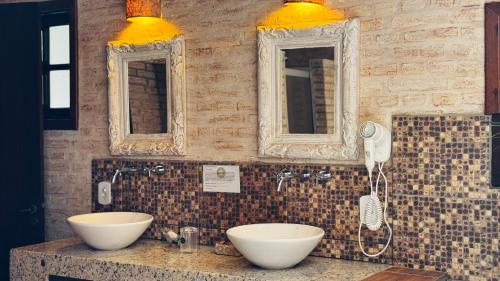 a bathroom with two sinks and two mirrors at Estalagem Wiesbaden in Monte Verde