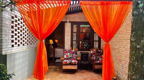 two orange curtains in front of a house at Estalagem Wiesbaden in Monte Verde