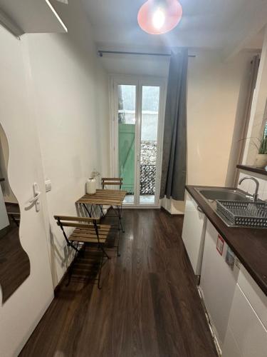 une cuisine avec un évier et une table avec des chaises dans l'établissement Estudio 20 m2, à Nice