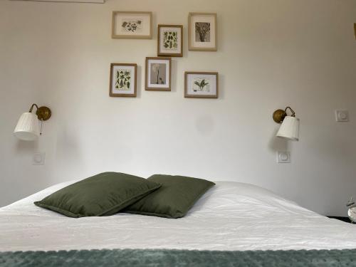 Cette chambre comprend un lit avec deux lampes et des photos murales. dans l'établissement La Maison Bonne Aventure, à Saint-Mitre-les-Remparts