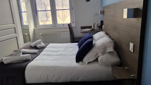a hotel room with a bed with towels on it at Hotel Logis Au Moyne de Saire in Réville