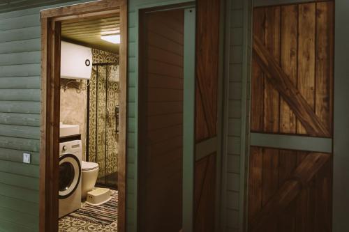 eine Tür, die zu einem Bad mit WC führt in der Unterkunft Luxury cabins with own sauna and hot-tub in Ķesterciems