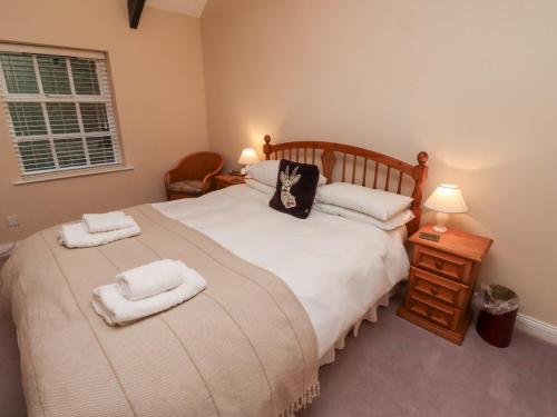 a bedroom with a bed with two towels on it at The Smithy in Wooler