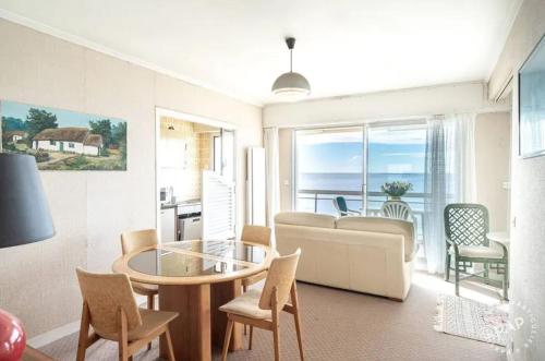 un salon avec un canapé, une table et des chaises dans l'établissement Appartement avec vue sur la mer à La Baule 62 m² tout équipé, à La Baule
