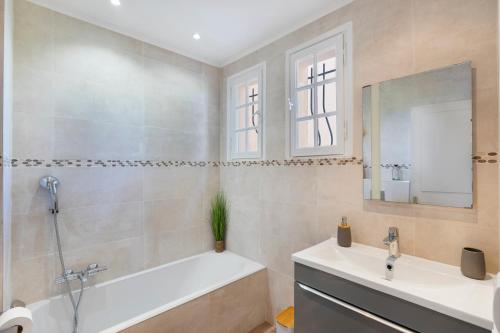 La salle de bains est pourvue d'une baignoire, d'un lavabo et d'un miroir. dans l'établissement Capleouna-Saint-Andrieu, à Villeneuve-Loubet