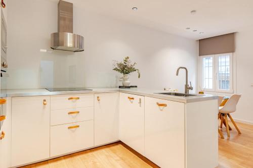 a kitchen with white cabinets and a sink at La casa de la Abuela in Marbella