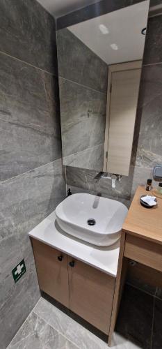 a bathroom with a white sink and a mirror at Hill Luxury Suite in Moírai