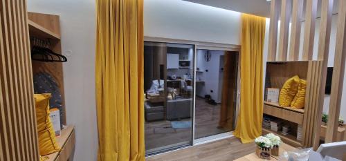 a room with yellow curtains and a living room at Hill Luxury Suite in Moírai
