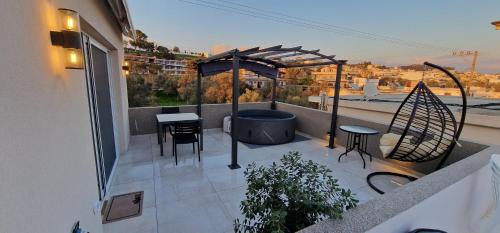 a balcony with a hot tub and a table and chairs at Hill Luxury Suite in Moírai