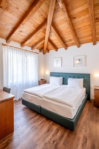 a large bed in a room with a wooden ceiling at Hotel Il Castagno in Mugena