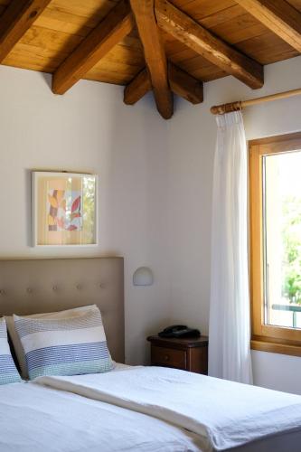 a bedroom with a white bed and a window at Hotel Il Castagno in Mugena