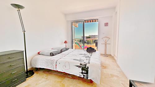 une chambre avec un grand lit et une fenêtre dans l'établissement Vista Mare, à Nice