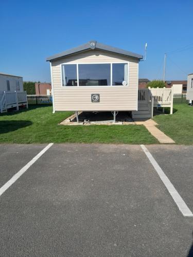 a mobile home parked in a parking lot at L83 amazing holiday home in Mablethorpe