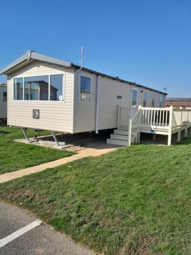 a mobile home with a porch and a deck at L83 amazing holiday home in Mablethorpe