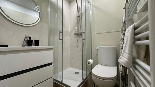 une salle de bain avec toilettes et douche en verre dans l'établissement Le Mario, à Nevers