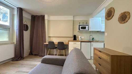 un salon avec un canapé et une cuisine dans l'établissement Le Mario, à Nevers