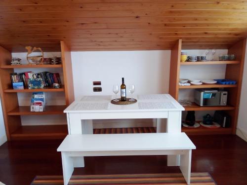 Una pequeña mesa blanca con una botella de vino. en Mundaka Vista Mar L-BI-52, en Mundaka