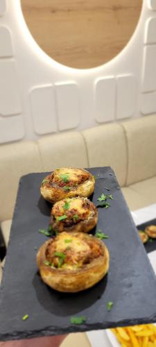 four small pizzas sitting on a black cutting board at Klebrido Hotel and Restaurant in Durrës