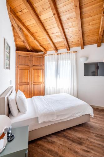 a bedroom with a large bed and wooden ceilings at Hotel Il Castagno in Mugena