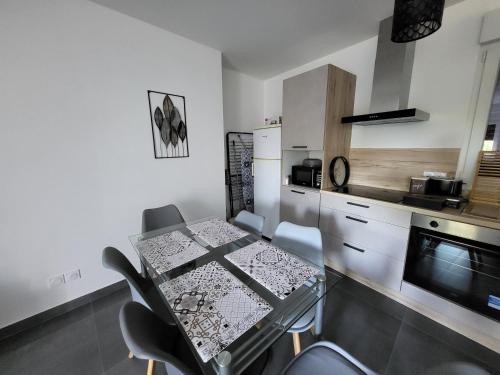 - une cuisine avec une table en verre, des chaises et un four micro-ondes dans l'établissement Appartement Ilena, à Lucinges