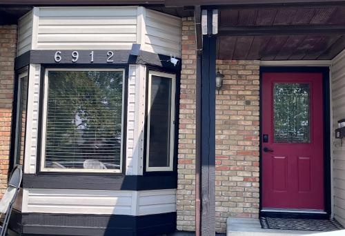 a house with a red door and a window at Gorgeous House&30 second Bus station Close C-Train& Free Parking in Calgary