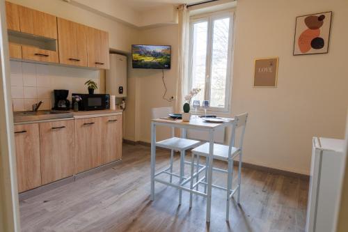 a kitchen with a table and chairs in a room at La Place Servant in Montluçon