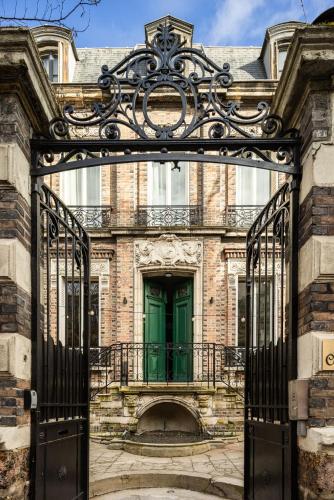 an entrance to a building with a green door at Le Charmant Hôtel in Saint-Ouen