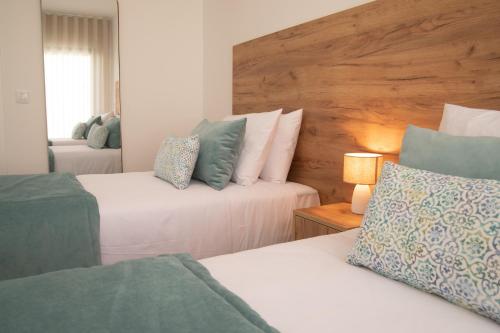 een slaapkamer met twee bedden en een houten hoofdeinde bij Casa Encanto da Foz - BY SCH in Foz do Arelho