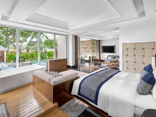 a bedroom with a large bed and a bath tub at Sofitel Bali Nusa Dua Beach Resort in Nusa Dua