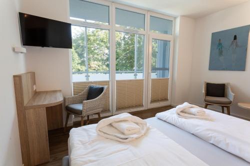 a hotel room with two beds and a window at Hotel Seebrücke in Lubmin