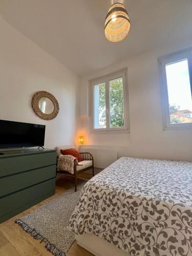 - une chambre avec un lit, une commode et des fenêtres dans l'établissement Laa Conciergerie, l'écrin vert des Chalets, à Toulouse