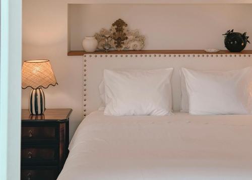 a bedroom with a bed with white pillows and a lamp at Quinta Amarela - B&B in Nazaré