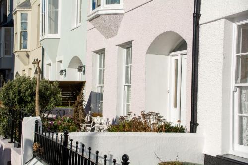 a white house with a white fence at 5 Raglan Street in Beaumaris
