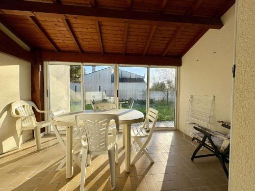 une salle à manger avec une table et des chaises blanches dans l'établissement Maison 3 pièces 4 couchages Saint Pierre d'Oléron SPO000-517, à Saint-Pierre-dʼOléron