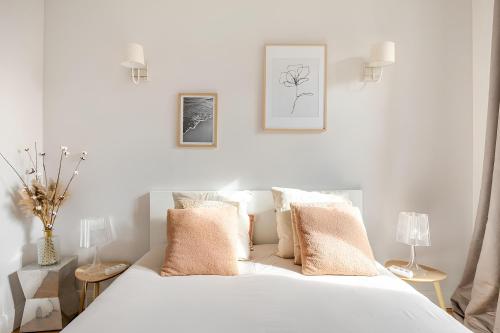 a bedroom with a white bed with pillows at Nancy Ville in Nancy