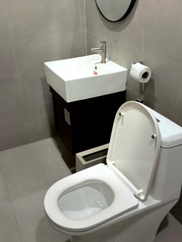 a bathroom with a white toilet and a sink at Thapmu-homie in Ban Lam Ru (1)