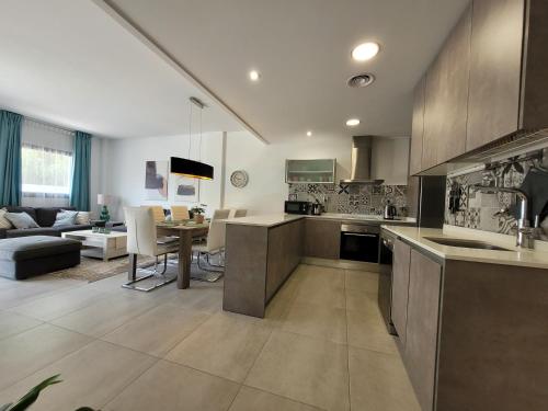 eine Küche und ein Wohnzimmer mit einer Couch und einem Tisch in der Unterkunft PMT01 - Modern, luxury with heated pool in Torrevieja