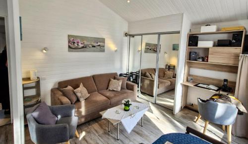 a living room with a couch and a table at Chalet in Plouër-sur-Rance