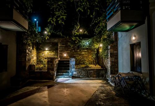 an alleyway at night with a stone wall at Nymfes in Tsagarada