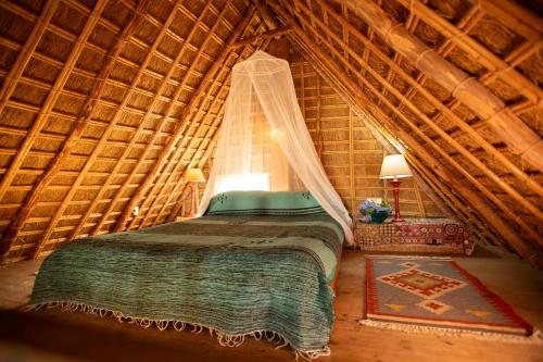 a bedroom with a bed in a thatched room at Casas Karen in Los Caños de Meca