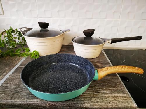 a frying pan on a counter with two pots at Kallithea metro station in Athens