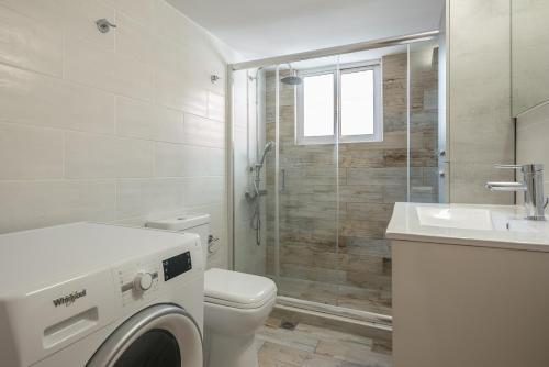 a bathroom with a toilet and a sink and a washing machine at Kallithea metro station in Athens