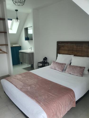 a bedroom with a large bed and a bathroom at stephane et virginie in Villemandeur