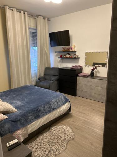 a bedroom with a bed and a couch and a tv at Stanza Dima in Monza