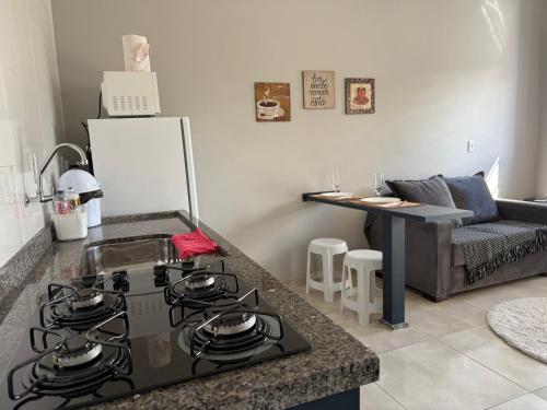 a kitchen with a stove top oven next to a couch at Loft Lohn 01 in Sorriso