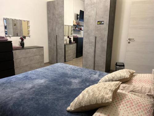a bedroom with a blue bed with pillows and a mirror at Stanza Dima in Monza