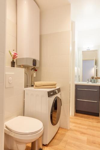 une salle de bain avec machine à laver et toilettes dans l'établissement Daumas 2 - Elégant appartement - central, à Toulon